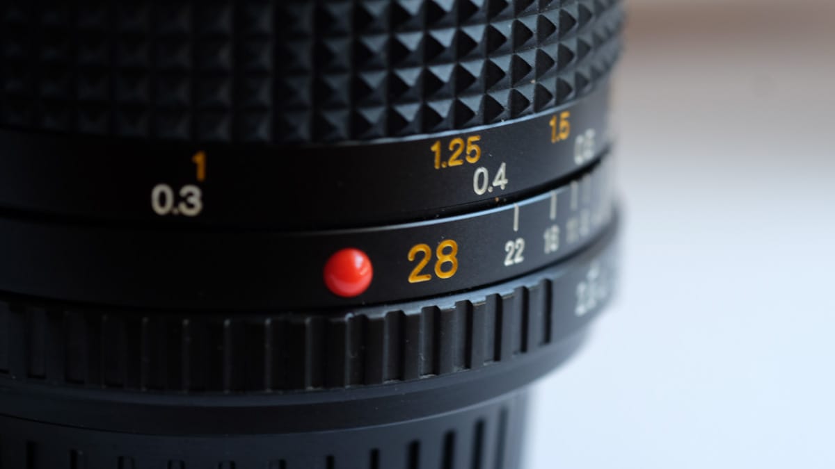 Close up image of a Minolta 28mm MD lens.